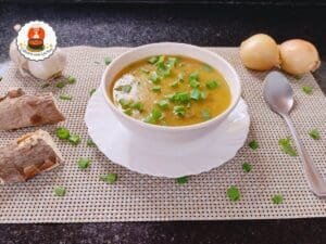 Tigela com caldo espesso de mandioca e carne desfiada, finalizado com cheiro-verde.
