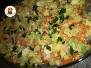 Travessa de vidro com maionese cremosa feita com batata, cenoura e temperos frescos.