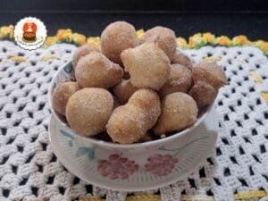 Bolinhos de chuva servidos com açúcar e canela.